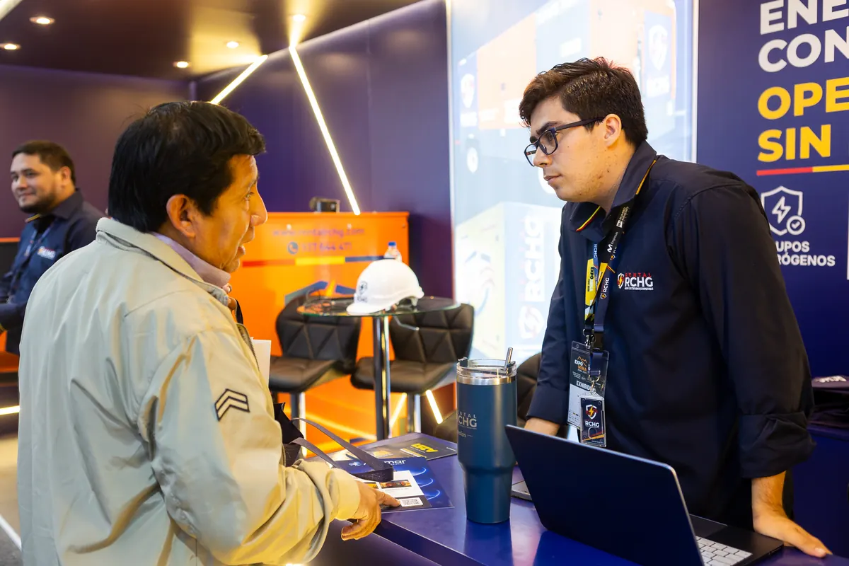 Integrante del equipo de Rental RCHG atiende a un visitante en el mostrador del stand A251 de ExpoMina 2026