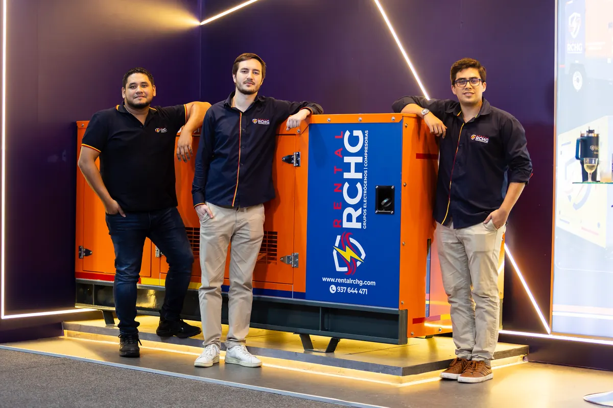 La gerencia de Rental RCHG junto al grupo electrógeno encapsulado exhibido en ExpoMina 2026
